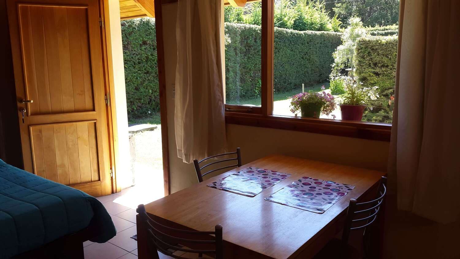 Dining table and park view of the monoambiente at Cabañas Denise